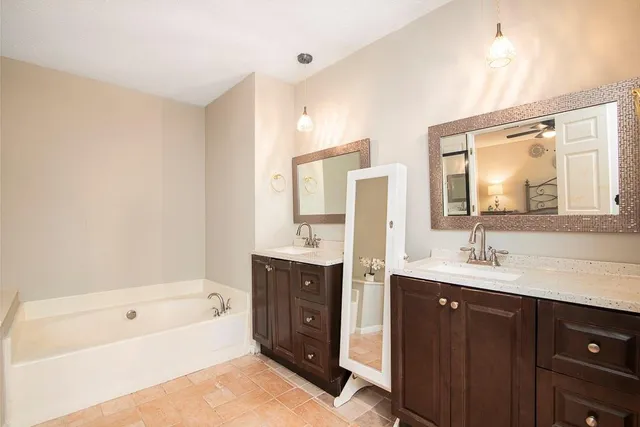 a bathroom with a tub sink and mirror