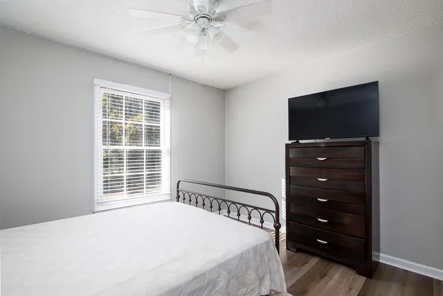 a bedroom with a bed and a flat tv screen on dresser