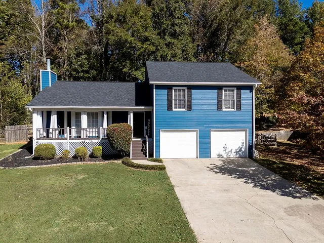 a front view of a house with a yard outdoor seating and garage
