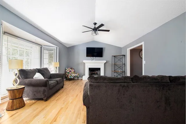 a living room with furniture a fireplace and a flat screen tv
