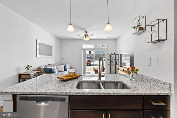 a kitchen with kitchen island granite countertop a sink a counter space and cabinets