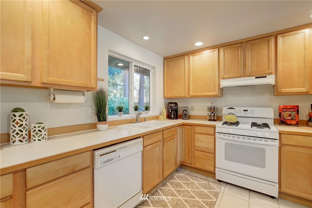 21930 3rd Place West Bothell, WA 98021 - Photo 4 of 34 a kitchen with white cabinets and white appliances
