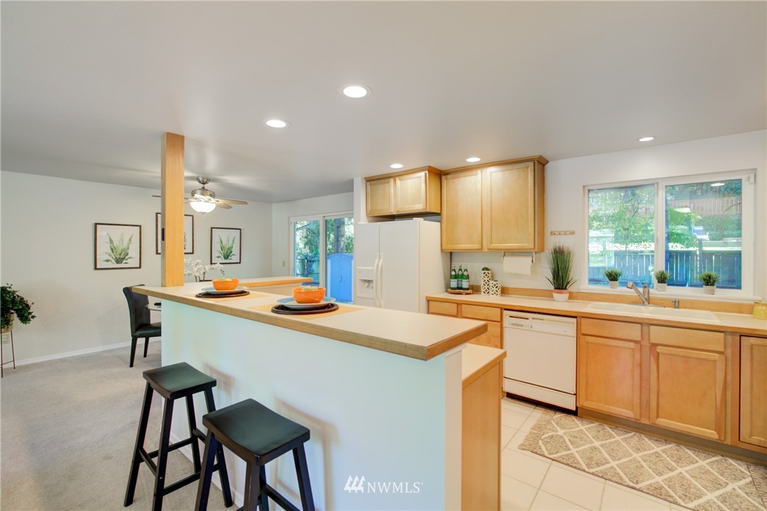 21930 3rd Place West Bothell, WA 98021 - Photo 6 of 34 a kitchen with stainless steel appliances kitchen island granite countertop a table chairs sink and cabinets