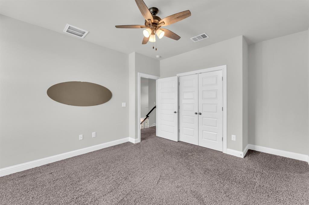 110 Magona Trail Georgetown, TX 78628 - Photo 24 of 38 A comfortable bedroom with plush carpet and a stylish ceiling fan.