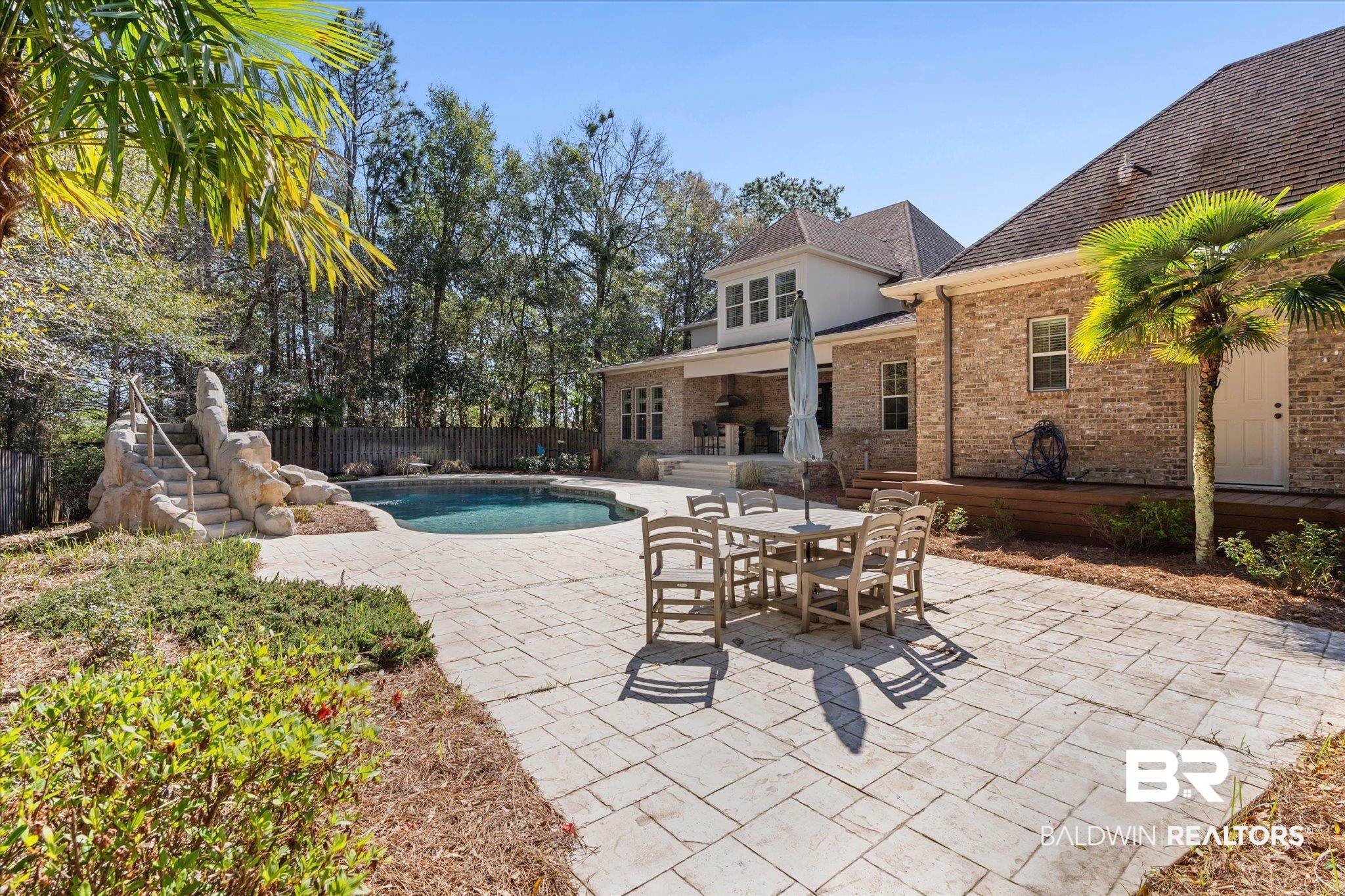 7676 Rockstone Lane Mobile, AL 36695 - Photo 38 of 47 View of swimming pool featuring patio surround, outdoor dining space, and a fenced backyard