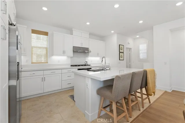 a kitchen with kitchen island a sink stove and white cabinets