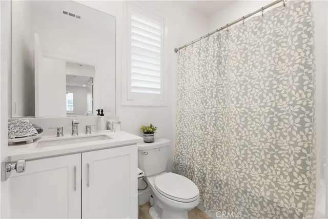 a bathroom with a toilet a sink and a mirror