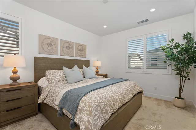 a bedroom with a bed and a potted plant