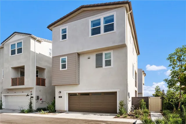 a front view of a house with garage and parking