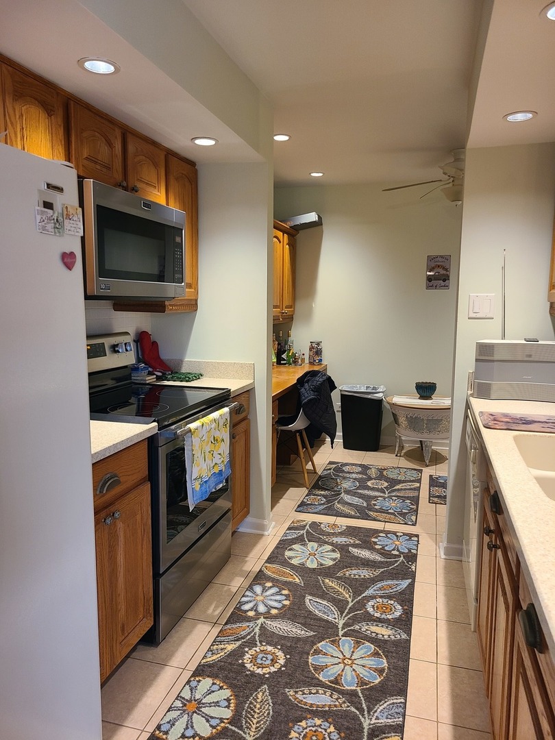 8359 West Addison Street, Unit 201 Chicago, IL 60634 - Photo 9 of 22 a kitchen with stainless steel appliances kitchen island granite countertop a stove and a sink