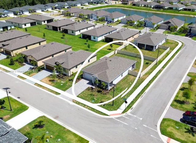 an aerial view of a house with a garden and lake view