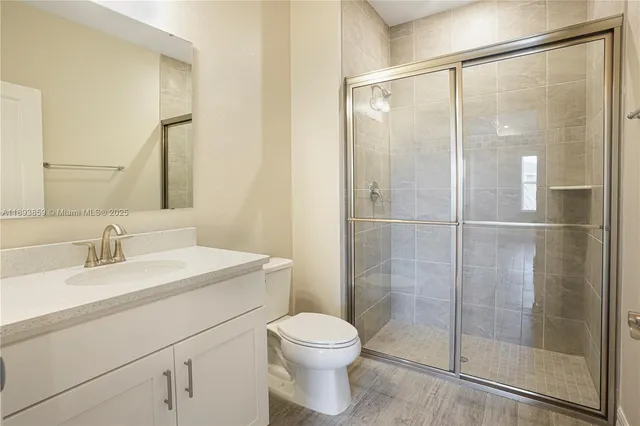 a bathroom with a shower a sink a toilet and mirror