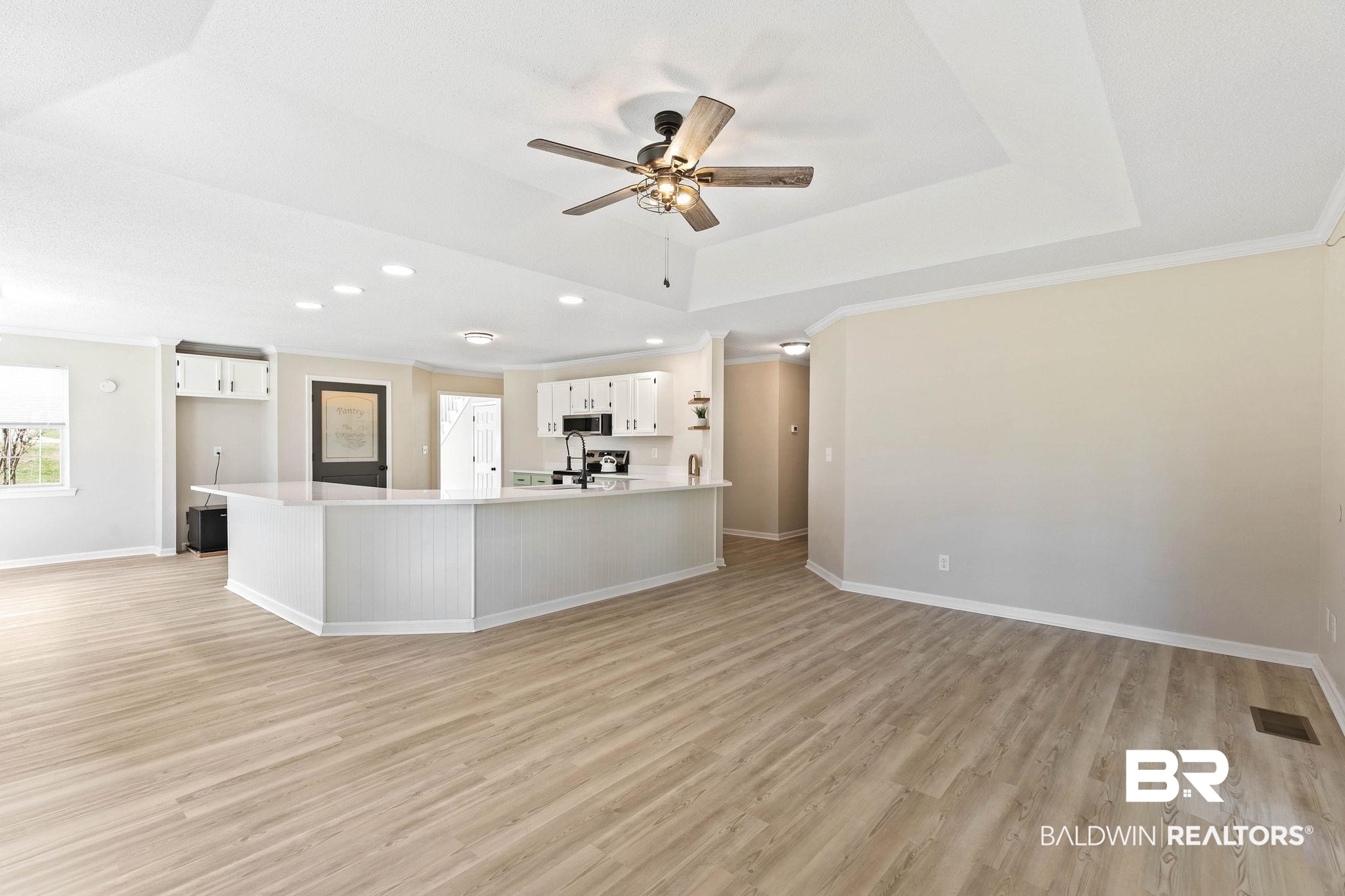 35650 Spring Road North Stapleton, AL 36578 - Photo 27 of 70 Unfurnished living room featuring light wood-style flooring, ornamental molding, a tray ceiling, a ceiling fan, and recessed lighting