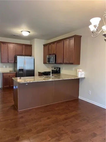 a kitchen with stainless steel appliances granite countertop a stove a sink and a refrigerator