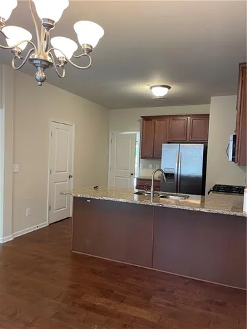 a kitchen with kitchen island granite countertop a sink cabinets and wooden floor