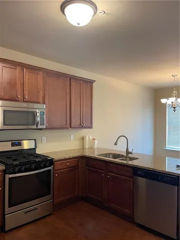 a kitchen with sink a microwave and cabinets