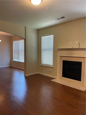 an empty room with wooden floor and fireplace