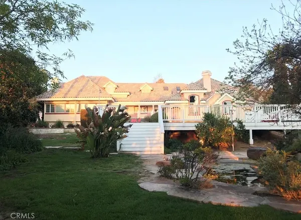 a view of a patio with table and chairs potted plants and a large tree