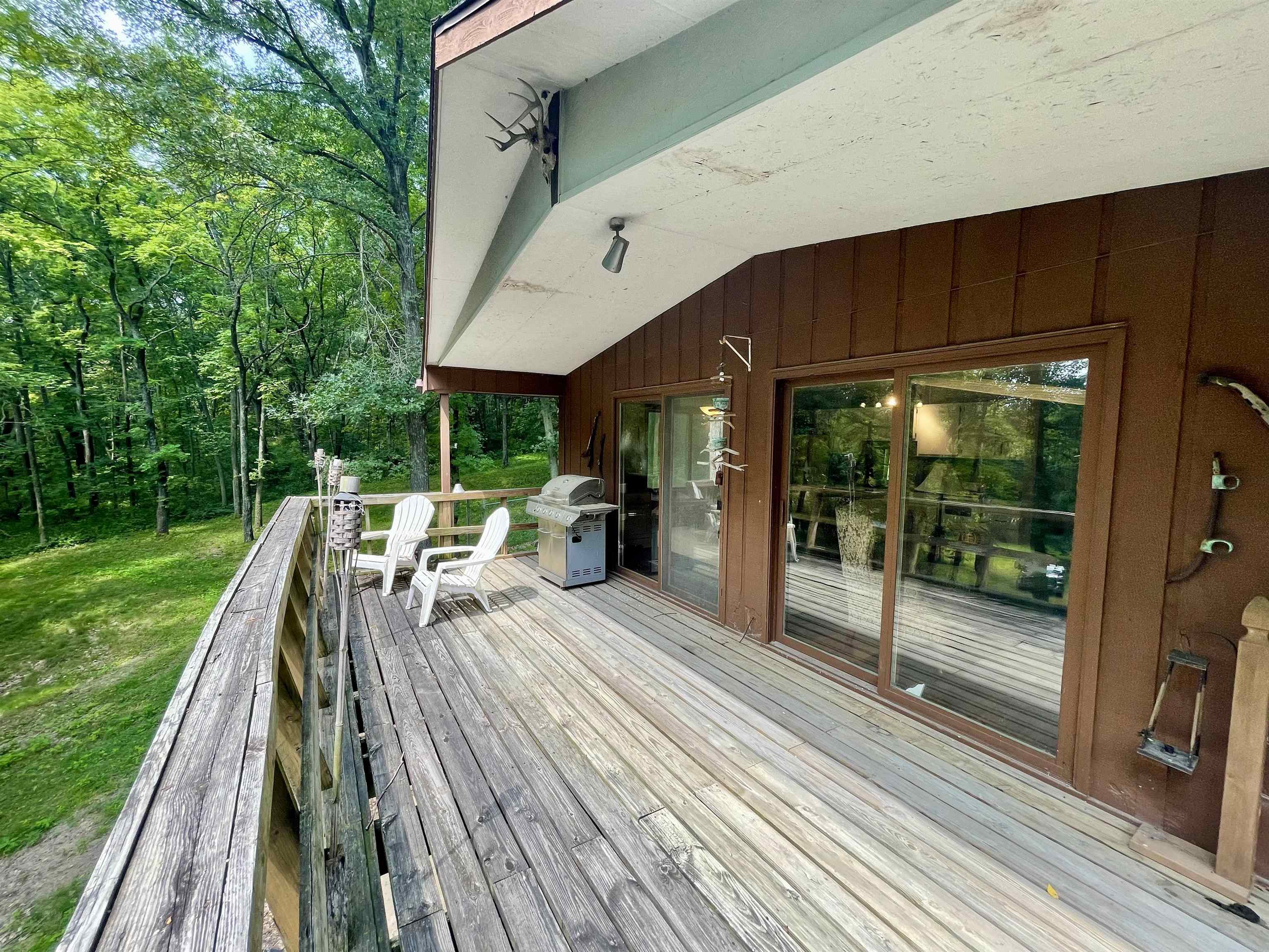 8008 West Blanding Road Hanover, IL 61041 - Photo 11 of 67 a view of a patio with table and chairs under an umbrella with wooden floor