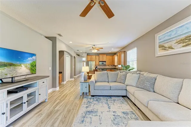 a kitchen with stainless steel appliances granite countertop a stove top oven a sink dishwasher a dining table and chairs with wooden floor