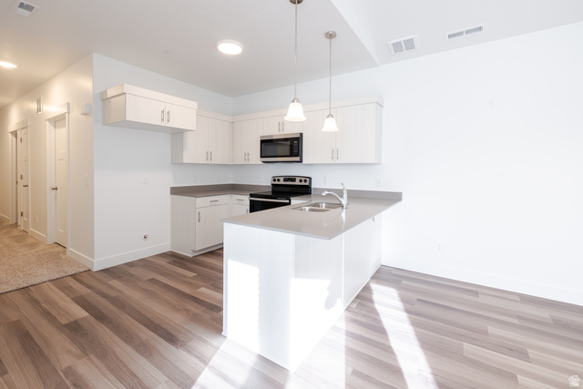 4662 Poplar Way, Unit Q301 Mapleton, UT 84664 - Photo 6 of 18 Kitchen featuring a peninsula, stainless steel appliances, hanging light fixtures, and light wood-style floors
