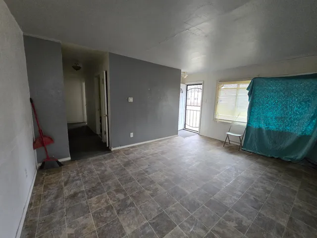a view of a kitchen with refrigerator and window