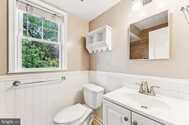 a bathroom with a sink a toilet and a window