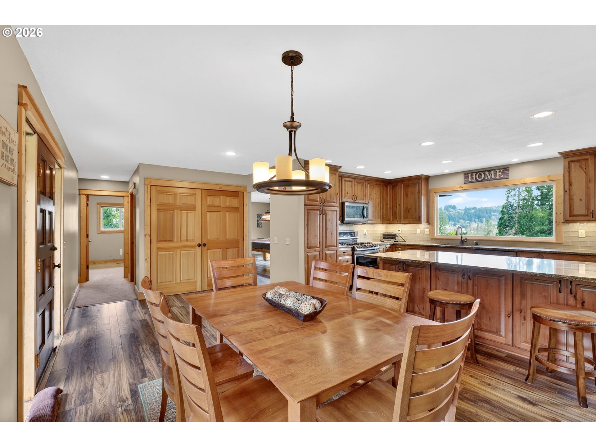 9732 Southeast Ladera Court Damascus, OR 97089 - Photo 18 of 41 a kitchen with stainless steel appliances granite countertop a dining table chairs and granite counter tops