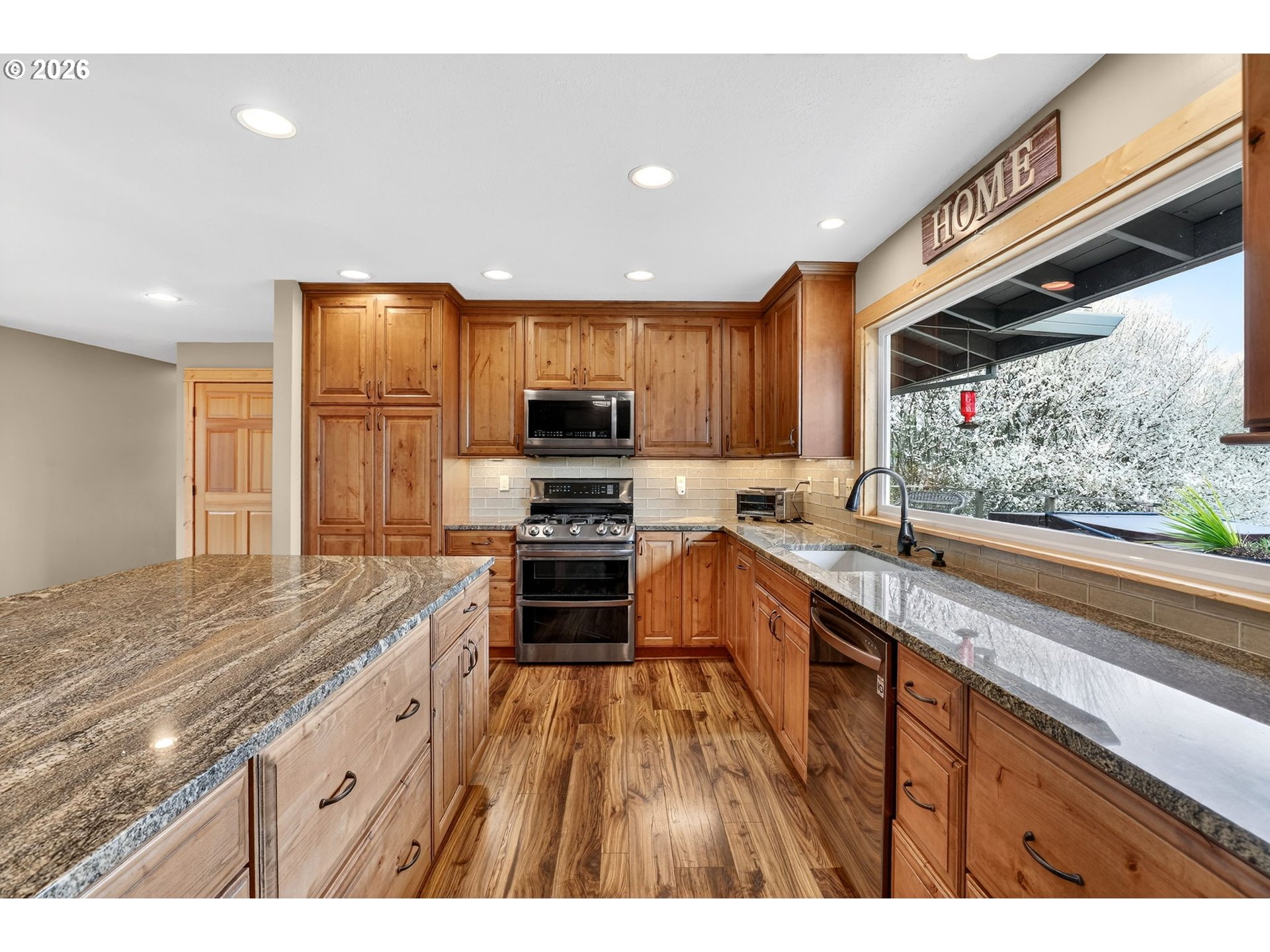 9732 Southeast Ladera Court Damascus, OR 97089 - Photo 10 of 41 a kitchen with kitchen island granite countertop a sink appliances cabinets and counter space