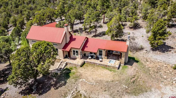 an aerial view of a house with swimming pool and bench