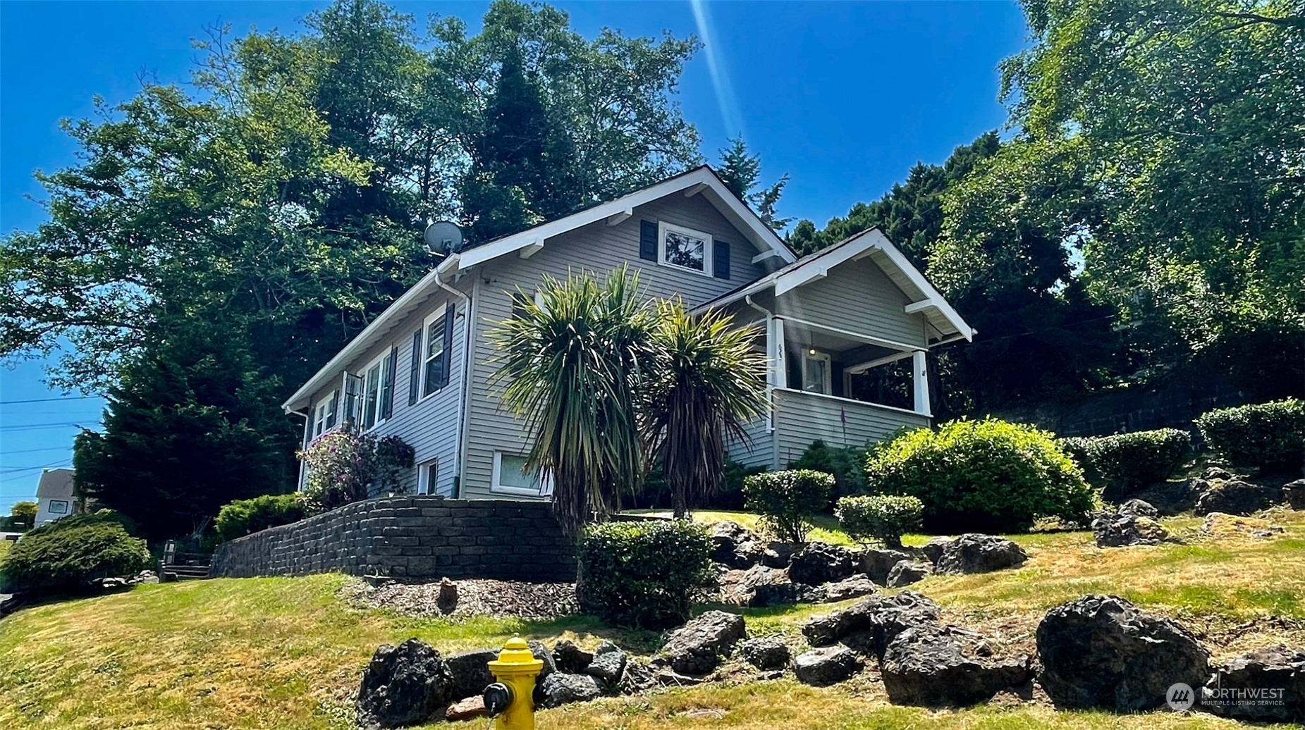 a front view of house with yard and trees in the background