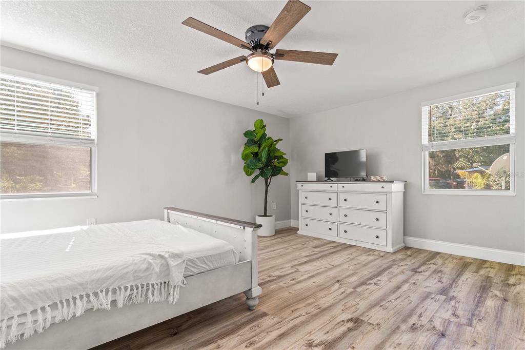 2716 Berdetta Street Leesburg, FL 34748 - Photo 15 of 35 a bedroom with a bed and a flat tv screen on dresser