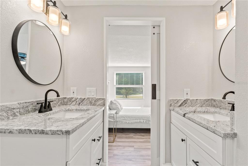 2716 Berdetta Street Leesburg, FL 34748 - Photo 16 of 35 a bathroom with a granite countertop sink and a mirror