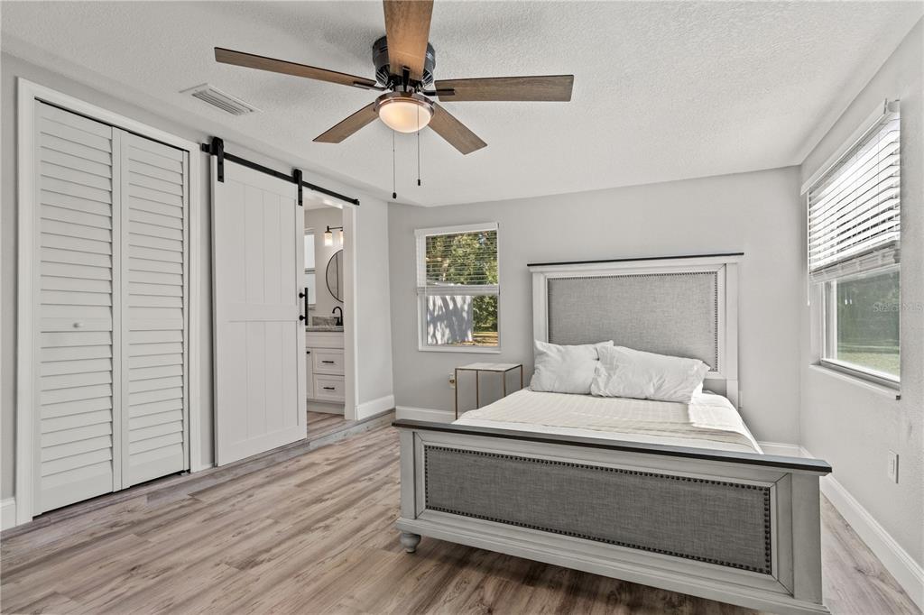 2716 Berdetta Street Leesburg, FL 34748 - Photo 10 of 35 a bedroom with a bed and a chandelier