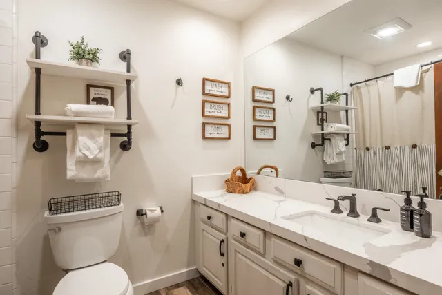a bathroom with a toilet sink and mirror