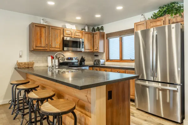a kitchen with stainless steel appliances granite countertop a sink a stove and a refrigerator