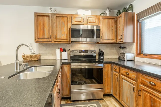 a kitchen with stainless steel appliances granite countertop a sink and a microwave