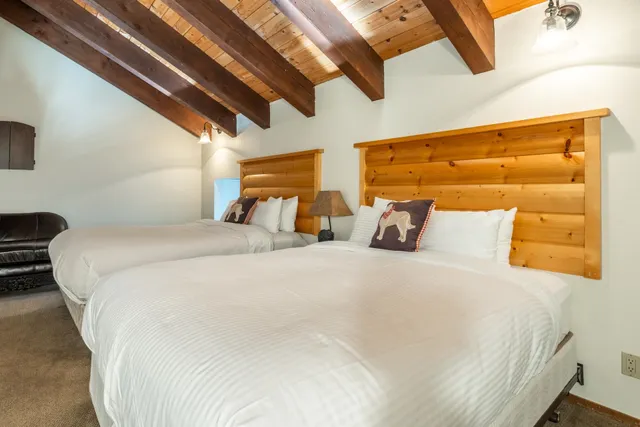 a large bed sitting in a bedroom next to a window