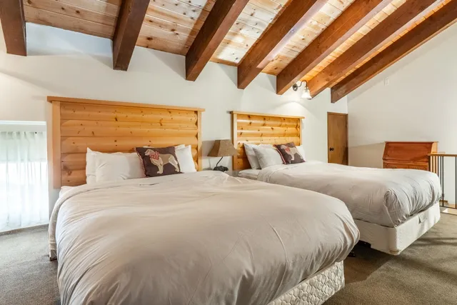 a large bed sitting in a bedroom next to a larger window