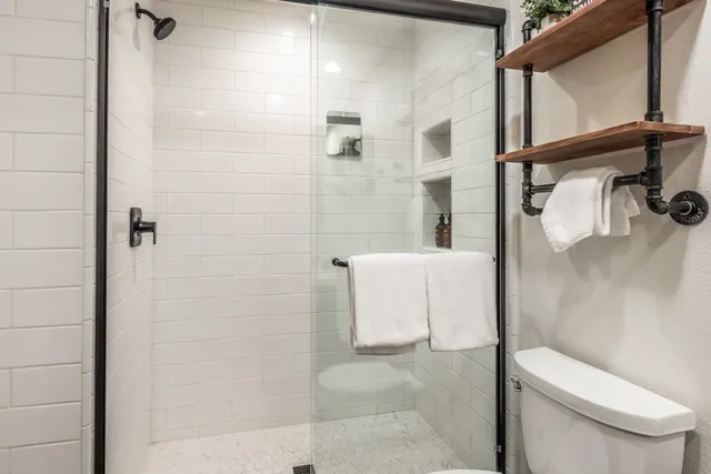 a bathroom with a toilet and a shower