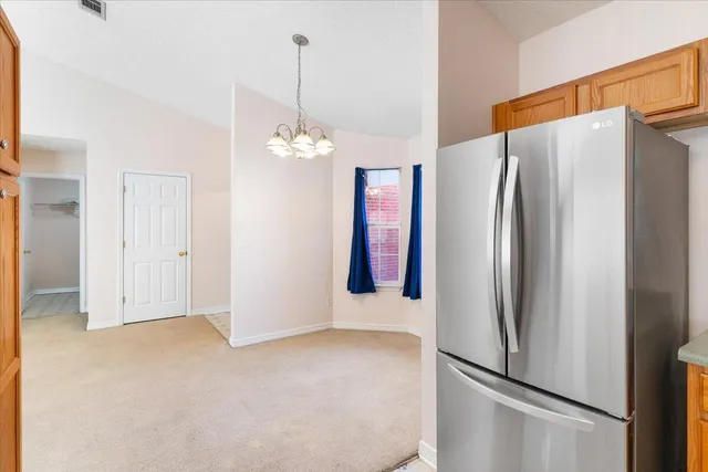 a view of a kitchen with refrigerator and cabinet