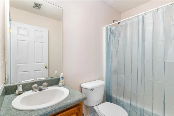 a bathroom with a toilet a sink and a mirror