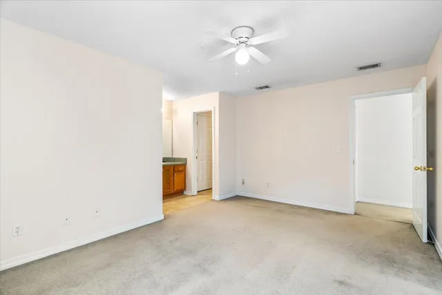 an empty room with a ceiling fan and a window