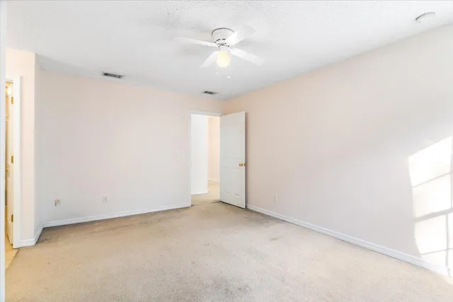 an empty room with a ceiling fan and a window