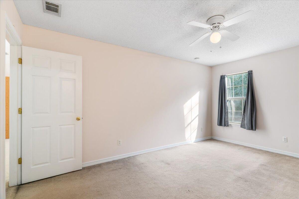 4640 Bobolink Way Crestview, FL 32539 - Photo 26 of 39 an empty room with chandelier fan and windows