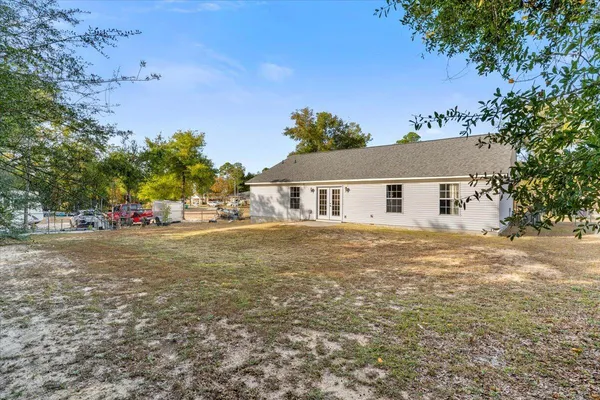 a front view of house with yard and trees in the background