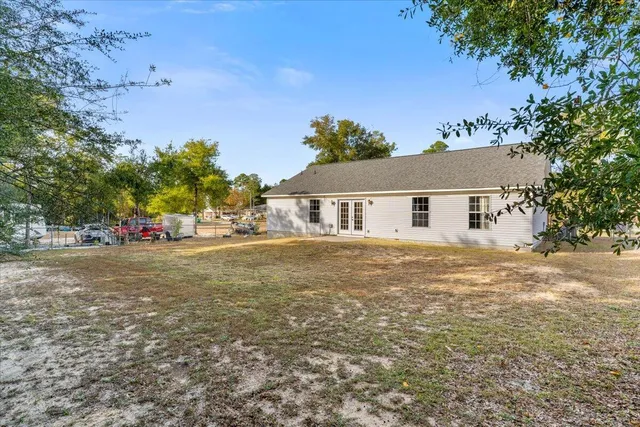 a front view of house with yard and trees in the background