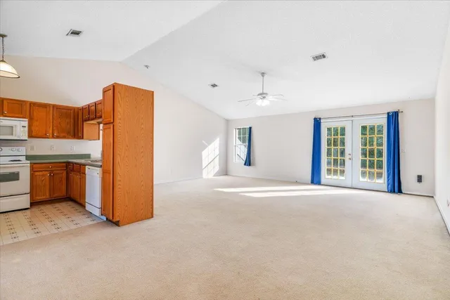 a view of a kitchen with refrigerator and window