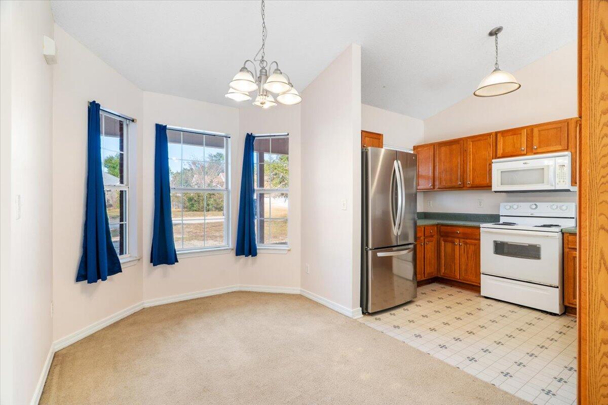 4640 Bobolink Way Crestview, FL 32539 - Photo 6 of 39 a kitchen with stainless steel appliances granite countertop a refrigerator a stove a sink dishwasher a oven with white cabinets and wooden floor