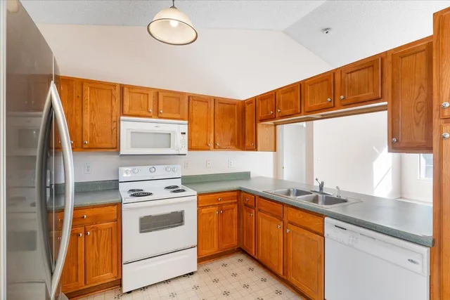 a kitchen with stainless steel appliances granite countertop a sink a stove and a refrigerator